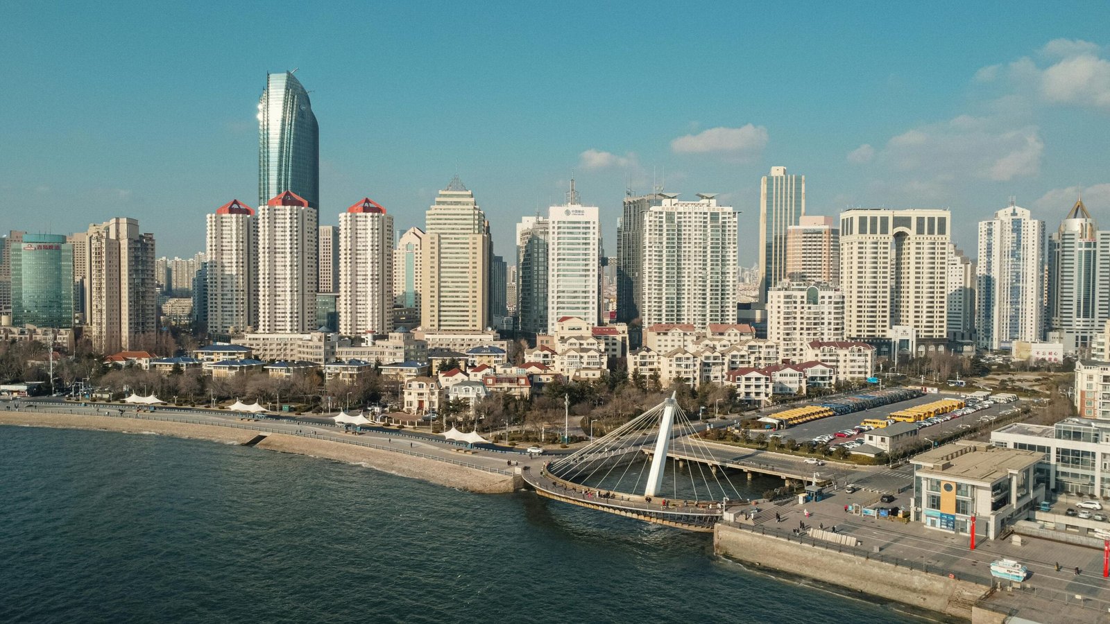 A stunning aerial photograph of Qingdao's city skyline and coastline in China.